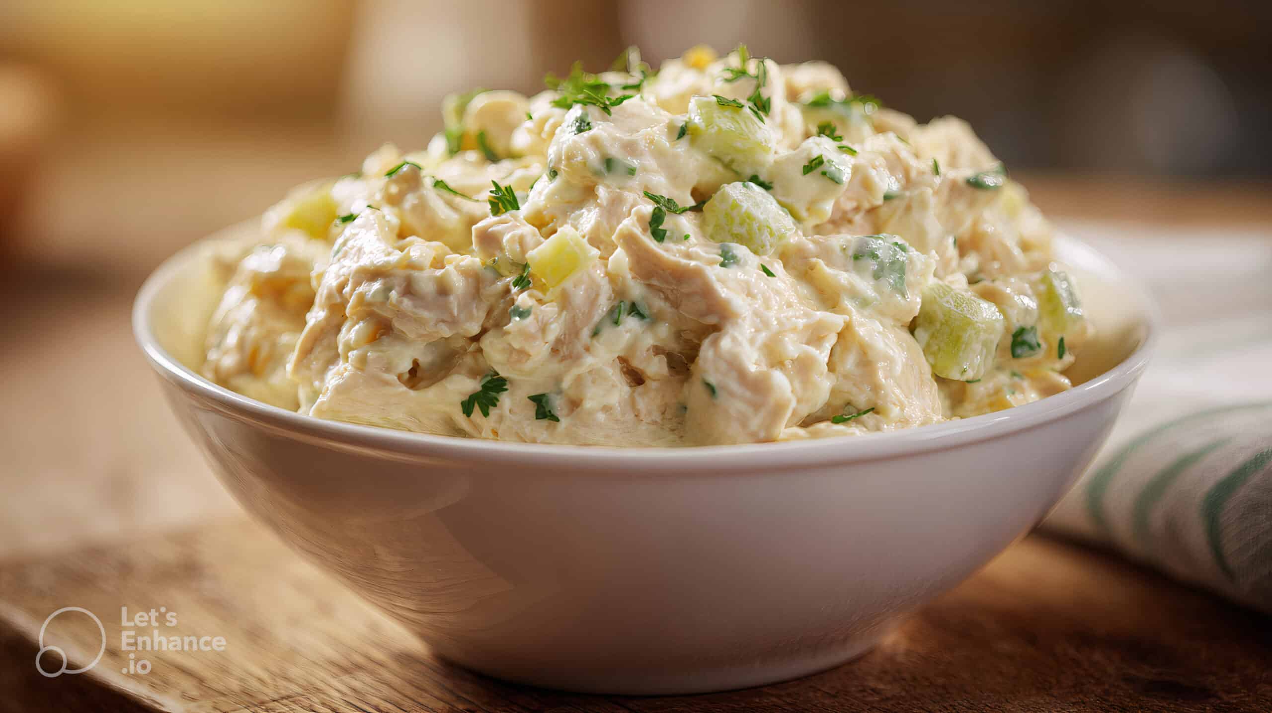 A wide, cinematic view of creamy canned chicken salad served in a rustic bowl on a wooden table. canned chicken salad recipe.